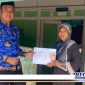 Caption: PJ Kades Torjun (Achmad Fadil), menyerahkan bantuan kepada warga tak tercover DTKS.