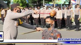 Caption: Kapolres Sampang menyiramkan air bunga kepada perwakilan 68 personel bintara remaja.
