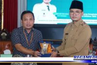 Caption: Kepala BPJS Kesehatan Madura Munaqib, menyerahkan cindera mata kepada Bupati Bangkalan Ra Latif, (Doc: Prokopim Pemkab Bangkalan).