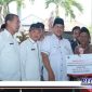 Caption: Wakil Bupati Bangkalan, Drs. Mohni menyerahkan bantuan Jaring Pengaman Sosial pada warga Bangkalan. (Doc: Syafin/RMN).