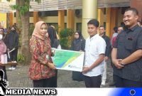 Caption: Kepala BPJS Ketenagakerjaan Madura serahkan kartu kepesertaan BPJS, (dok. regamedianews).