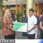 Caption: Kepala BPJS Ketenagakerjaan Madura serahkan kartu kepesertaan BPJS, (dok. regamedianews).