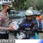 Caption: Satlantas Polres Bangkalan bagikan jas hujan kepada pengendara roda dua, (dok. regamedianews).