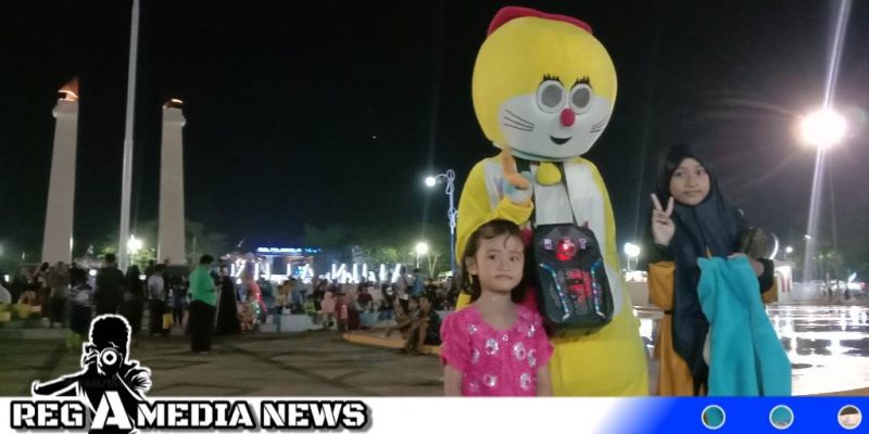 Caption: dua bocah pose bersama badut boneka di Alun-Alun Trunojoyo Sampang, (dok. regamedianews).