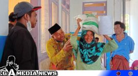 Caption: Pj Kades Karang Penang Onjur bantu warga saat terima bantuan pangan, (dok. regamedianews).