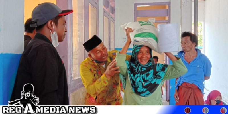 Caption: Pj Kades Karang Penang Onjur bantu warga saat terima bantuan pangan, (dok. regamedianews).