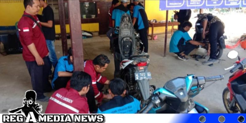 Caption: Pelajar SMKN 1 Omben bersama Polsek Omben berikan pelayanan service motor gratis kepada masyarakat, (dok. regamedianews).