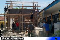 Caption: kekompakan warga dan Satgas TMMD Kodim 0828 Sampang saat pengerjaan pemasangan kerangka atap ruang guru SDN Pasarenan 2, (dok. regamedianews). 