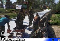 Caption: Satgas TMMD Kodim 0828 saat mengerjakan pembangunan plengsengan sisi rabat beton di Desa Pasarenan, (dok. regamedianews). 