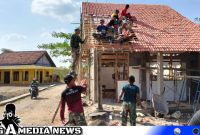 Caption: Satgas TMMD Kodim 0828 Sampang kompak pasang genteng ruang guru SDN Pasarenan 2, (dok. regamedianews). 