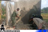 Caption: Satgas TMMD Kodim 0828 Sampang tengah melakukan pemelesteran dinding MCK, (dok. regamedianews). 