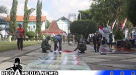 Caption: tampak personel Kodim 0828 Sampang memasang banner persiapan upacara penutupan program TMMD di halaman Pendopo Trunojoyo, (dok. regamedianews). 