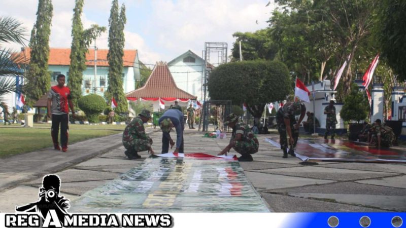 Caption: tampak personel Kodim 0828 Sampang memasang banner persiapan upacara penutupan program TMMD di halaman Pendopo Trunojoyo, (dok. regamedianews). 