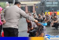 Caption: anggota Polres Pamekasan yang naik pangkat disirami air kembang bersamaan diguyur hujan, (dok. regamedianews). 