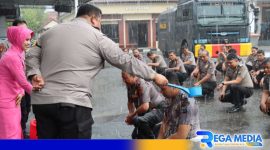 Caption: anggota Polres Pamekasan yang naik pangkat disirami air kembang bersamaan diguyur hujan, (dok. regamedianews). 