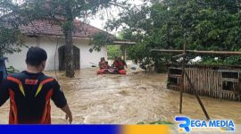 Caption: Tim BPBD Sampang mengevakuasi warga terancam banjir menggunakan perahu karet, (dok. regamedianews). 