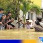 Caption: anggota Polres Sampang tampak memberikan bantuan kepada korban banjir, (dok. regamedianews). 