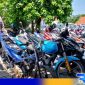 Caption: KBO Satlantas Polres Sampang tunjukkan motor knalpot brong yang diamankan, (dok. regamedianews). 