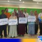 Caption: Kepala BPJS Ketenagakerjaan Madura pose bersama tenaga buruh yang menerima santunan JKM. 