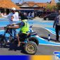Caption: anggota Satlantas Polres Sampang mendampingi penyandang disabilitas saat uji teori mengemudi, (dok. regamedianews). 