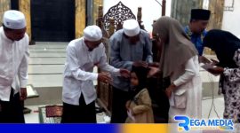 Caption: didampingi kiai dan lurah, takmir masjid jami' Asy-Syuhadak memberikan santunan kepada anak yatim, (dok. regamedianews). 