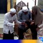 Caption: didampingi kiai dan lurah, takmir masjid jami' Asy-Syuhadak memberikan santunan kepada anak yatim, (dok. regamedianews). 