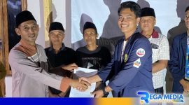 Caption: perwakilan kelompok KKN-01 berjabat tangan dengan Perangkat Desa Telaga Biru, (dok. regamedianews). 