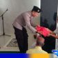 Caption: Ps Kanit Bintibsos Satbinmas Polres Sampang membagikan bendera merah putih kepada jamaah Musholla Al-Amin, (dok. regamedianews). 