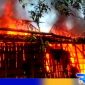 Caption: tampak seluruh bagian belakang rumah yang berdinding kayu dilalap api, (dok. regamedianews). 