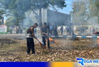 Caption: tampak pegawai Lapas Narkotika Pamekasan kerja bakti membersihkan Taman Makam Pahlawan (TMP). 