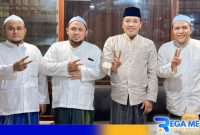 Caption: Cabup Sampang H. Slamet Junaidi pose dua jari bersama KH. Mahrus, serta kedua putranya KH. Zakariya dan KH. Zamzami, (dok. regamedianews). 