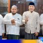 Caption: Cabup Sampang H. Slamet Junaidi pose dua jari bersama KH. Mahrus, serta kedua putranya KH. Zakariya dan KH. Zamzami, (dok. regamedianews). 