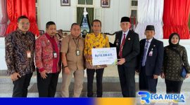 Caption: Pj Bupati Bangkalan (Arief M. Edie) didampingi Kepala BPJamsostek Madura (Indriyatno) menyerahkan santunan JKM, JHT dan Beasiswa. 