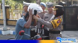 Caption: Wakapolres Sampang Kompol Hosna Nurhidayah memberikan helm kepada pengendara, (dok. Humas Polri). 