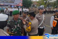 Caption: Kapolres Sampang AKBP Hendro Sukmono sematkan pita kepada perwakilan personel gabungan, (dok. Humas Polri). 