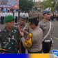 Caption: Kapolres Sampang AKBP Hendro Sukmono sematkan pita kepada perwakilan personel gabungan, (dok. Humas Polri). 