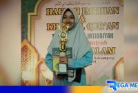Caption: Siti Aisyah santri Madrasah Amirussalam saat menerima reward dan piala bintang pelajar periode tahun 2024-2025, (dok. regamedianews). 