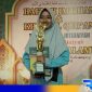 Caption: Siti Aisyah santri Madrasah Amirussalam saat menerima reward dan piala bintang pelajar periode tahun 2024-2025, (dok. regamedianews). 