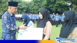 Caption: mewakili BPJS Ketenagakerjaan Cabang Madura, Pj Bupati Bangkalan menyerahkan santunan jaminan sosial kepada Ahli Waris Tenaga Non-ASN/Tenaga Harian Lepas (THL). 