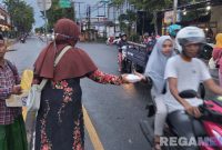 Caption: Ketua IWO Pamekasan membagikan langsung makanan kepada pengguna jalan, (dok. regamedianews). 