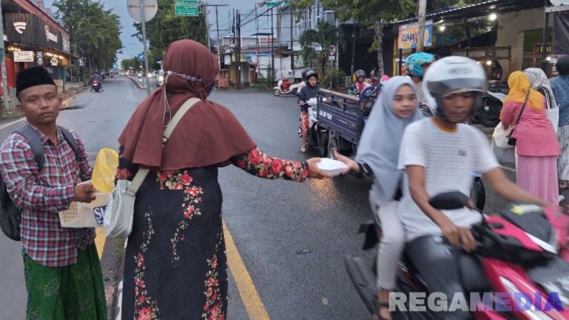Caption: Ketua IWO Pamekasan membagikan langsung makanan kepada pengguna jalan, (dok. regamedianews). 