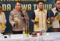 Caption: Kabid Humas dan Dirreskrimsus Polda Jatim tunjukkan barang bukti minyak goreng yang dioplos, (sumber foto: Tribrata News). 