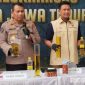 Caption: Kabid Humas dan Dirreskrimsus Polda Jatim tunjukkan barang bukti minyak goreng yang dioplos, (sumber foto: Tribrata News). 