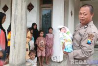 Caption: anggota Polsek Banyuates menggendong bayi perempuan yang ditemukan warga di persawahan, (sumber foto: Humas Polri). 