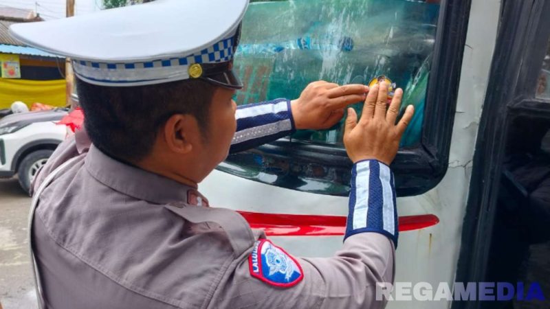 Caption: anggota Satlantas Polres Sampang saat memasang stiker 