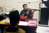 Caption: Kanit PPA Satreskrim Polres Sampang tunjukkan barang bukti dan meminta keterangan pelaku, (sumber foto. Humas Polri). 