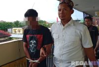 Caption: tersangka KDRT dikawal penyidik Satreskrim Polres Sampang ke sel tahanan, (dok. regamedianews). 