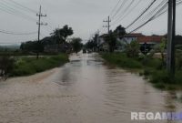 Caption: luapan air sungai kali Kamoning sudah mulai menggenangi sebagian ruas jalan raya menuju arah Sampang kota maupun sebaliknya, (dok. Tim BPBD Sampang). 