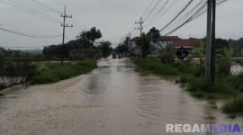 Caption: luapan air sungai kali Kamoning sudah mulai menggenangi sebagian ruas jalan raya menuju arah Sampang kota maupun sebaliknya, (dok. Tim BPBD Sampang). 