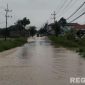 Caption: luapan air sungai kali Kamoning sudah mulai menggenangi sebagian ruas jalan raya menuju arah Sampang kota maupun sebaliknya, (dok. Tim BPBD Sampang). 